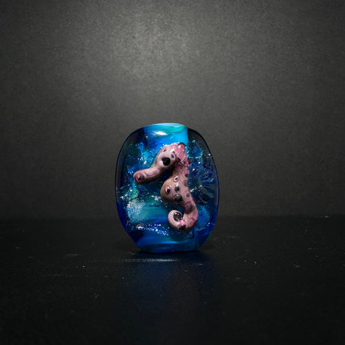 Purple Sea Horse Bead on an Ocean Themed Back Ground with Dichroic.